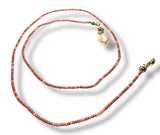 Necklace with red beads and gold clasp on a white background