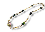 Gold chain bracelet with multicolored beads on a white background