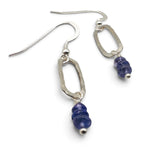 A pair of silver drop earrings with textured oval dangles and stacked blue lapis lazuli beads, shown on a plain white background.