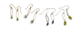 4 pairs of dangling earrings arranged on a plain white background. The earrings feature elongated open metal links in gold and silver tones, with green, blue, and gray stone or bead accents.