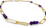 Gold chain necklace with purple beads on a white background