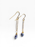A pair of gold dangle earrings with teardrop-shaped blue and white marbled gemstone pendants, shown on a clean white background.