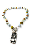 A beaded necklace with a rectangular silver pendant featuring a sunrise design, displayed on a clean white background.