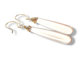 Gold-wrapped clear teardrop earrings on a white background