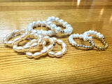 Pearl Rings and bracelet set on a wooden surface