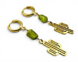 Gold earrings with green beads on a white background