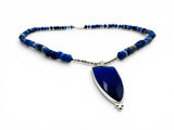 Blue beaded necklace with a large blue pendant on a white background. Peruvian Opal and Glass Necklace.