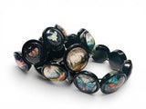 A black stretch bracelet featuring multiple oval links with colorful butterfly and landscape illustrations, displayed on a clean white background.