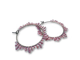 Pair of pink beaded hoop earrings on a white background
