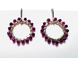 Hoop earrings with pink quartz gemstones on a white background.