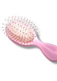 Pink hairbrush with bristles on a white background
