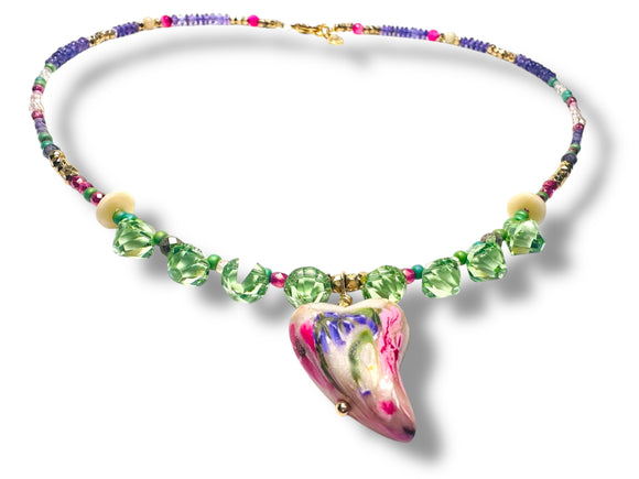 Colorful beaded necklace with a pink and green pendant on a white background