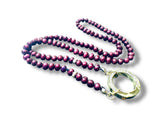 Purple pearl necklace with a gold clasp on a white background