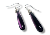 Purple teardrop earrings with silver hooks on a white background