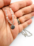 Rose Quartz / Silver Paw charm close up in hand