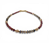 Necklace with multicolored beads on a white background. Ruby, Iolite and Pearl Bracelet