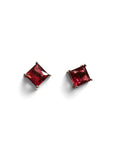 A pair of stud earrings featuring square-cut deep red gemstones in a silver-toned prong setting, displayed on a clean white background with soft shadows.