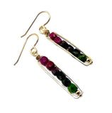 Pair of gold earrings with green and red gemstones on a white background. Ruby Zoisite Golden Earrings 