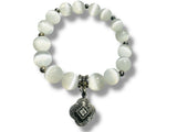 Selenite Beaded bracelet with a silver charm on a white background