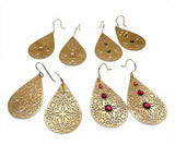 Set of gold teardrop earrings with various designs on a white background