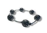 Silver bracelet with black beaded charms on a white background
