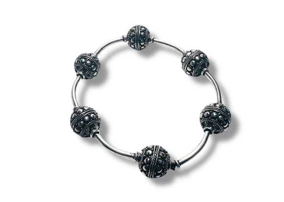 Silver bracelet with black bead accents on a white background