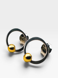 A pair of modern hoop earrings with a polished silver-tone circular frame and a small, textured gold-tone sphere hanging from each hoop, shown on a light gray background.