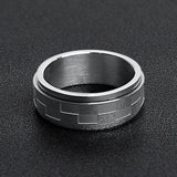 Silver ring with carbon fiber inlay on a black textured background