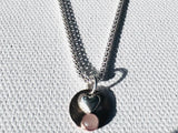 Necklace with a heart-shaped pendant on a textured white background