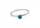 Silver ring with a blue gemstone on a white background