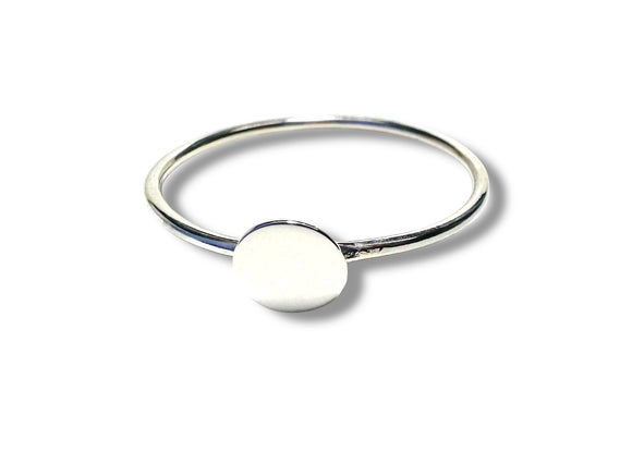 Silver ring with a round white stone on a white background
