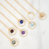 Gold necklaces with gemstone pendants on a white background