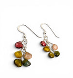 A pair of handmade dangle earrings featuring polished, irregular multicolor gemstones in red, yellow, green, and peach, suspended from silver-toned French hook wires on a white background.