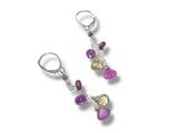 Silver earring with colorful gemstones on a white background