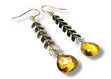 Gold earrings with yellow Citrine gemstones on a white background