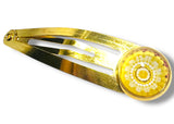Gold hair clip with a decorative yellow center on a white background
