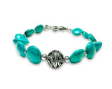 Turquoise beaded bracelet with a silver clasp on a white background