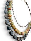  A multi-strand beaded necklace featuring dark blue kyanite, jasper, and a delicate silver chain with iolite beads, displayed on a clean white background.