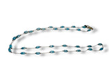Long necklace with blue beads on a white background