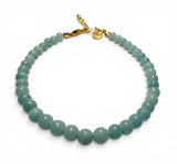 Teal beaded bracelet with a gold clasp on a white background