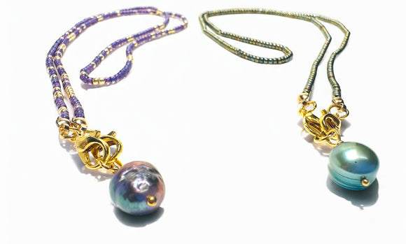 Two necklaces with colorful beads and gold clasps on a white background