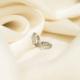 Silver ring with gemstones on a soft beige fabric background