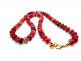Necklace with red beads and a gold clasp on a white background