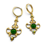 A pair of gold leverback drop earrings with green cabochon gemstones and small iridescent accents, shown on a plain white background.