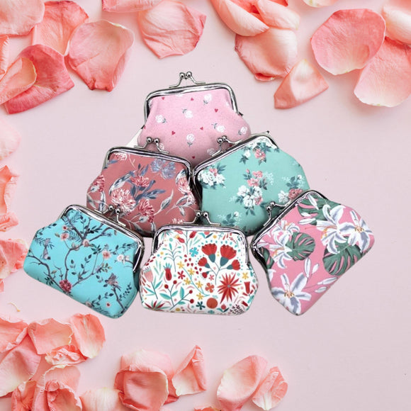 Set of floral patterned coin purses on a pink background with flower petals.