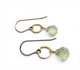 Pair of gold earrings with green gemstones on a white background