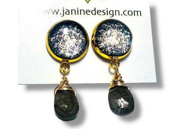 Pair of earrings with gold accents and black stones on a white card with 'www.janinedesign.com' text.