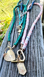 Gemstone Charm Necklace - assorted charm necklaces shown outside on wood