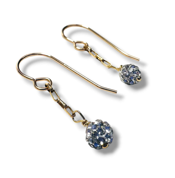 Gold earrings with blue gemstones on a white background