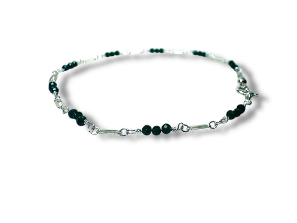 Bracelet with green goldstone beads on a white background